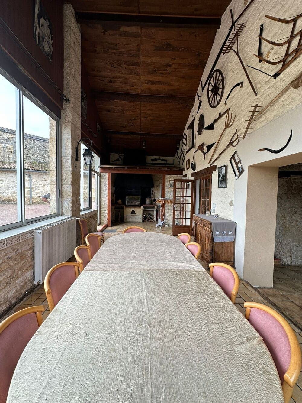 La deuxième salle du bar du Domaine du Vieux Lavoir, un espace lumineux grâce à ses grandes baies vitrées offrant une belle vue sur le parc. Idéale pour un moment de calme, une conversation ou une pause rafraîchissante, cette salle complète parfaitement l'ambiance de vos mariages et grandes réceptions dans les Deux-Sèvres, offrant un confort supplémentaire à vos invités.