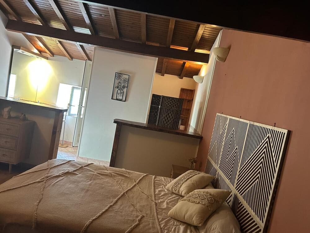 La chambre du Gîte Pampas au Domaine du Vieux Lavoir, avec un lit confortable au premier plan et, en arrière-plan, l'accès à sa salle de bain et toilettes privatives. Cet agencement assure un confort optimal et une intimité précieuse pour vos invités. Idéale pour se préparer et se reposer en toute tranquillité après les célébrations de vos mariages et grandes réceptions dans les Deux-Sèvres,cette suite garantit un séjour des plus agréables.