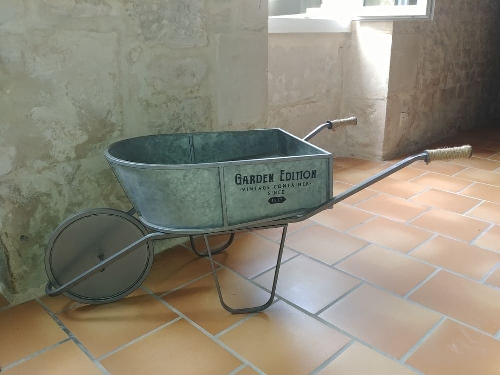 Une charmante petite brouette décorative au sein du Gîte Pampas au Domaine du Vieux Lavoir, ajoutant une touche rustique et originale à l'aménagement intérieur. Ce détail inattendu illustre l'attention portée à la création d'une atmosphère unique et accueillante dans nos hébergements. Il contribue au charme authentique que nous offrons à vos invités pour vos mariages et grandes réceptions dans les Deux-Sèvres, invitant à la découverte de chaque recoin.