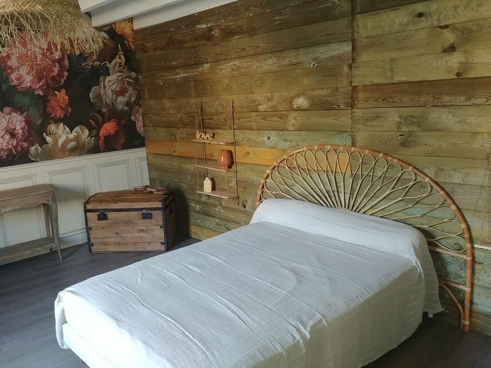 La chambre au rez-de-chaussée du Gîte Pivoine au Domaine du Vieux Lavoir, aménagée avec un lit double confortable. Cet espace douillet et facilement accessible est parfait pour un couple, offrant un havre de paix pour se reposer. Elle contribue à la diversité des options d'hébergement que nous proposons pour vos mariages et grandes réceptions dans les Deux-Sèvres, assurant un confort optimal à tous vos invités.