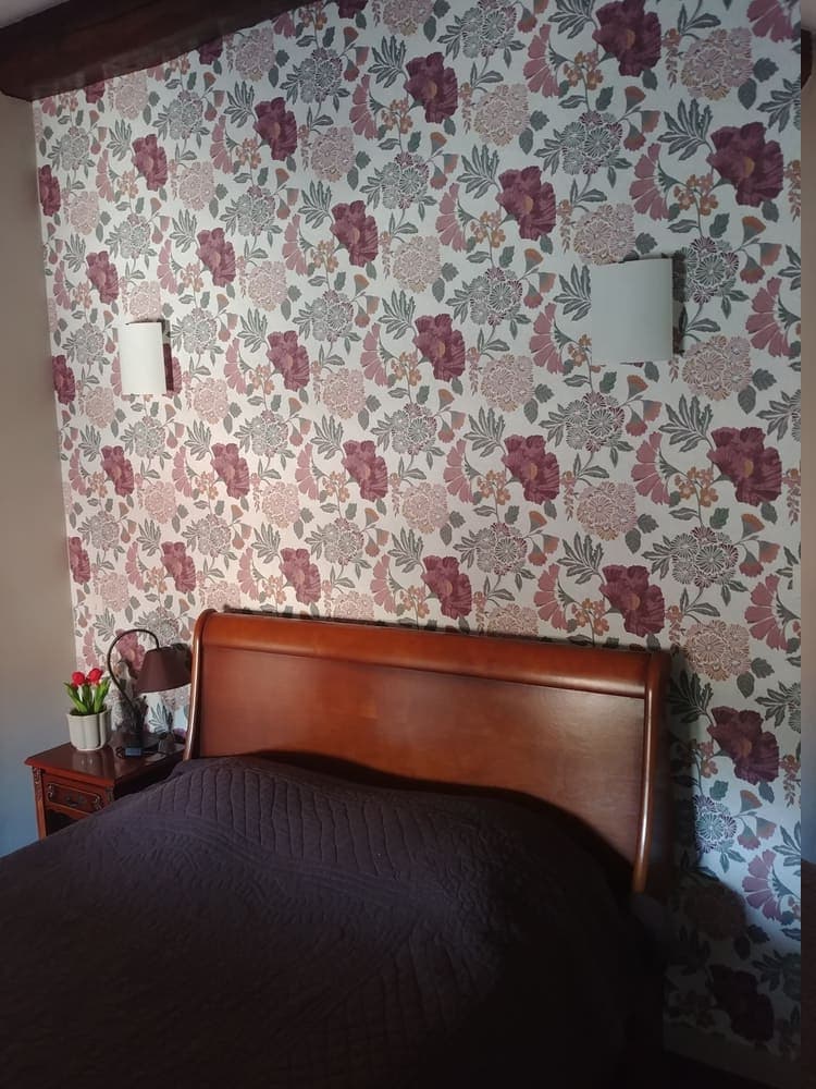 La première chambre douillette du deuxième étage du Gîte Pivoine au Domaine du Vieux Lavoir, équipée d'un confortable lit double. Cet espace paisible et intime est idéal pour un couple, offrant un havre de repos après les festivités. Bien que non visible sur cette image, cette chambre bénéficie de sa propre salle d'eau privative, assurant un confort optimal et une autonomie appréciable pour les invités de vos mariages et grandes réceptions dans les Deux-Sèvres.