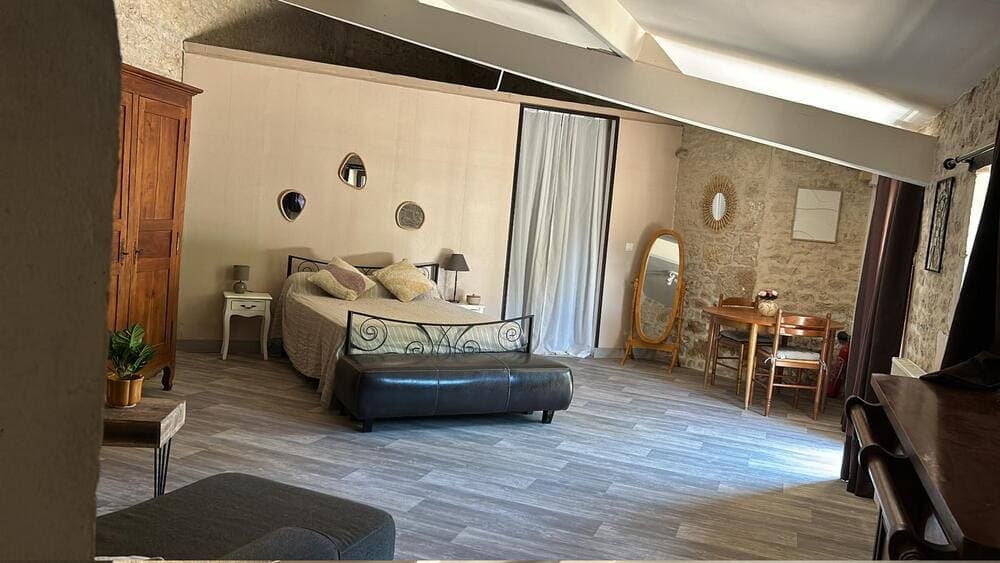 L'espace confortable et accessible du Gîte Rose au Domaine du Vieux Lavoir, conçu pour les Personnes à Mobilité Réduite (PMR). Cette photo montre la pièce principale, combinant harmonieusement chambre avec lit et salon avec table et chaises. Ce gîte offre un hébergement pensé pour le confort de tous vos invités lors de vos mariages et grandes réceptions dans les Deux-Sèvres, garantissant une autonomie et une sérénité complètes.