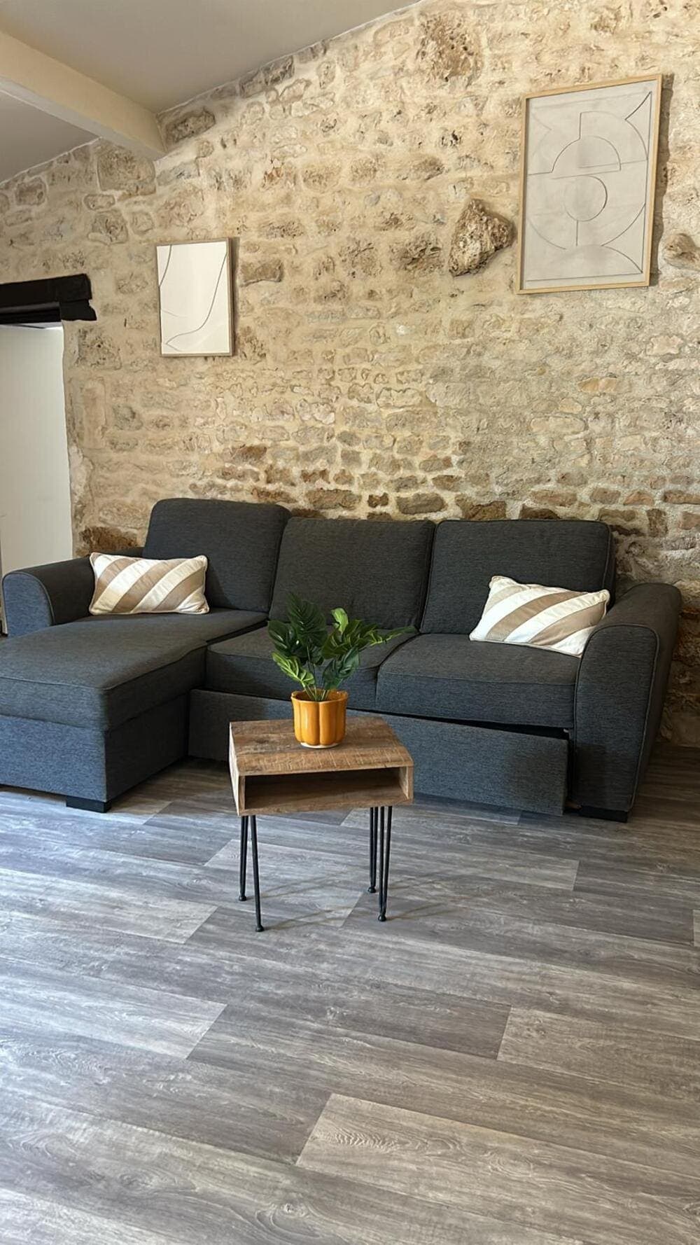 Le coin salon confortable du Gîte Rose au Domaine du Vieux Lavoir, avec son canapé douillet et sa petite table basse. Cet espace de détente, situé dans notre gîte accessible aux Personnes à Mobilité Réduite (PMR), est parfait pour se reposer ou partager un moment convivial après les célébrations de vos mariages et grandes réceptions dans les Deux-Sèvres, offrant un confort optimal à tous les invités.