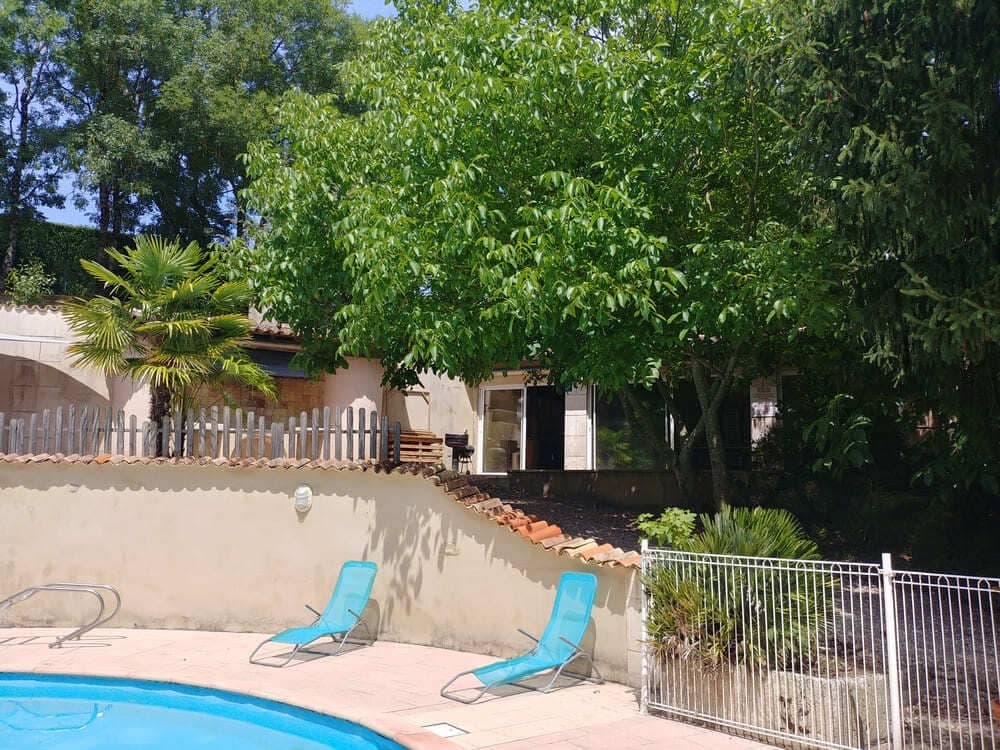 La piscine du Domaine du Vieux Lavoir, bordée de transats confortables invitant à la détente, avec le pool house visible en arrière-plan. Cet espace de loisirs complet offre un cadre idéal pour se rafraîchir et se détendre. C'est l'endroit parfait pour vos invités de profiter du soleil des Deux-Sèvres lors de vos mariages et grandes réceptions, assurant un moment de pur bien-être.