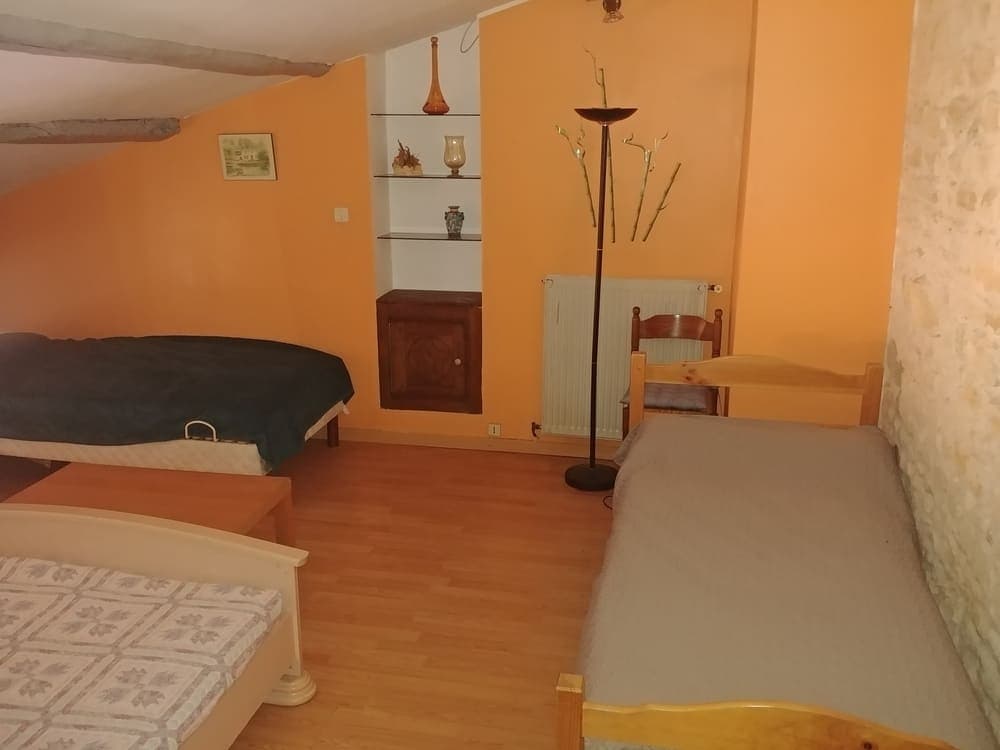 La chambre familiale du Gîte Lilas au Domaine du Vieux Lavoir, offrant un aménagement confortable avec un lit double et deux lits simples. Cet espace lumineux et accueillant est parfaitement adapté pour les familles ou les groupes d'amis participant à vos mariages et grandes réceptions dans les Deux-Sèvres, garantissant un sommeil paisible et réparateur pour tous les invités.