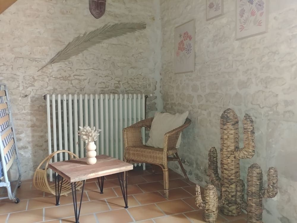 Un charmant petit coin détente dans le Gîte Pampas au Domaine du Vieux Lavoir, illustré par une petite table et une chaise, agrémentées de cactus décoratifs en osier. Cette touche originale et cosy, typique de la décoration de nos gîtes, offre un espace intime pour un café ou un moment de lecture. Elle contribue à l'atmosphère chaleureuse et accueillante que nous offrons à vos invités pour vos mariages et grandes réceptions dans les Deux-Sèvres.