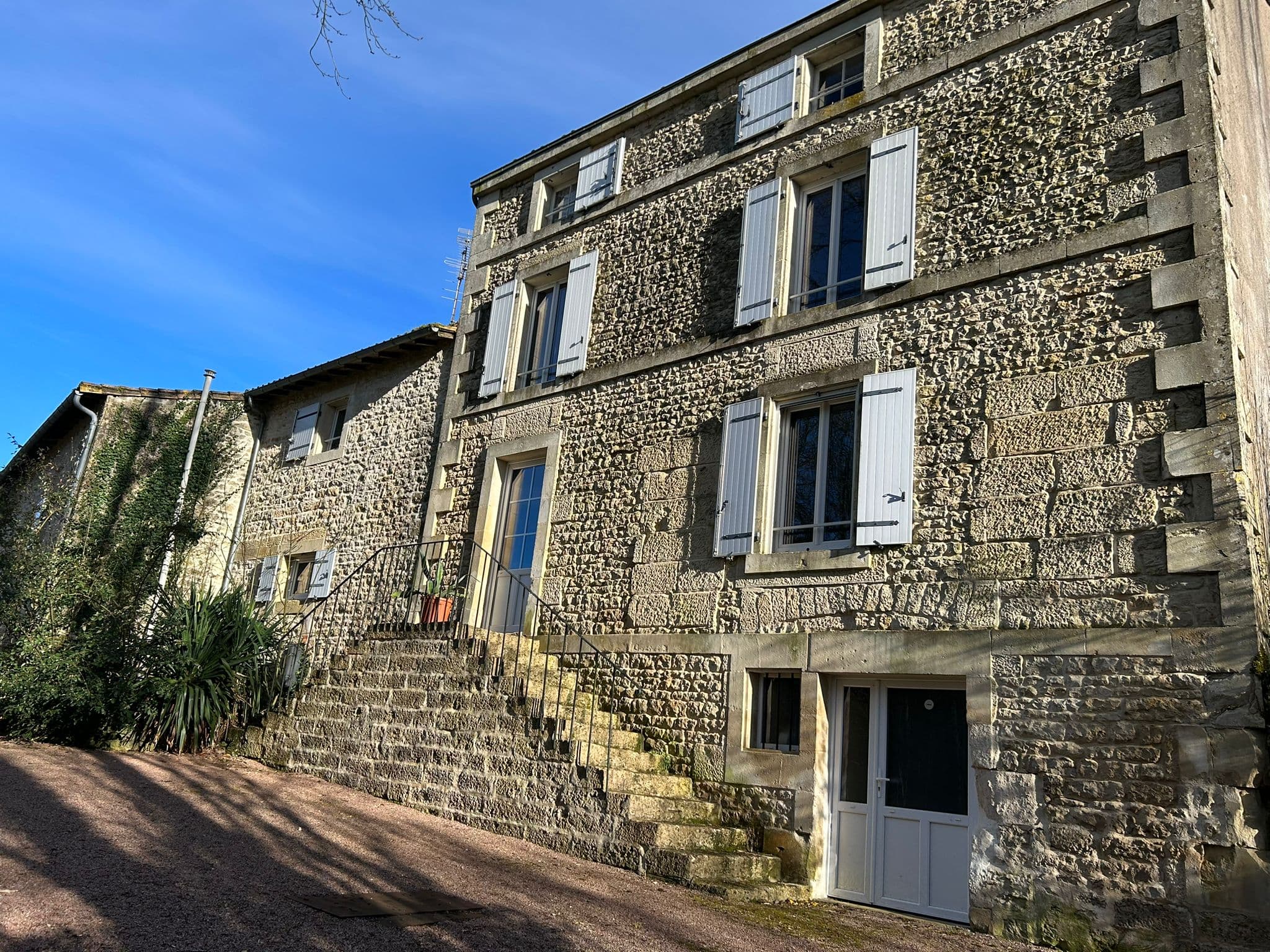 La façade extérieure du Gîte Pivoine au Domaine du Vieux Lavoir, s'élève sur trois étages (rez-de-chaussée + 2 étages) avec son escalier caractéristique. Ce gîte spacieux fait partie de nos 4 hébergements sur place, pouvant accueillir jusqu'à 55 personnes , offrant un confort optimal et une capacité d'accueil idéale pour les invités de vos mariages et grandes réceptions dans les Deux-Sèvres. Un cadre charmant et fonctionnel pour un séjour prolongé.