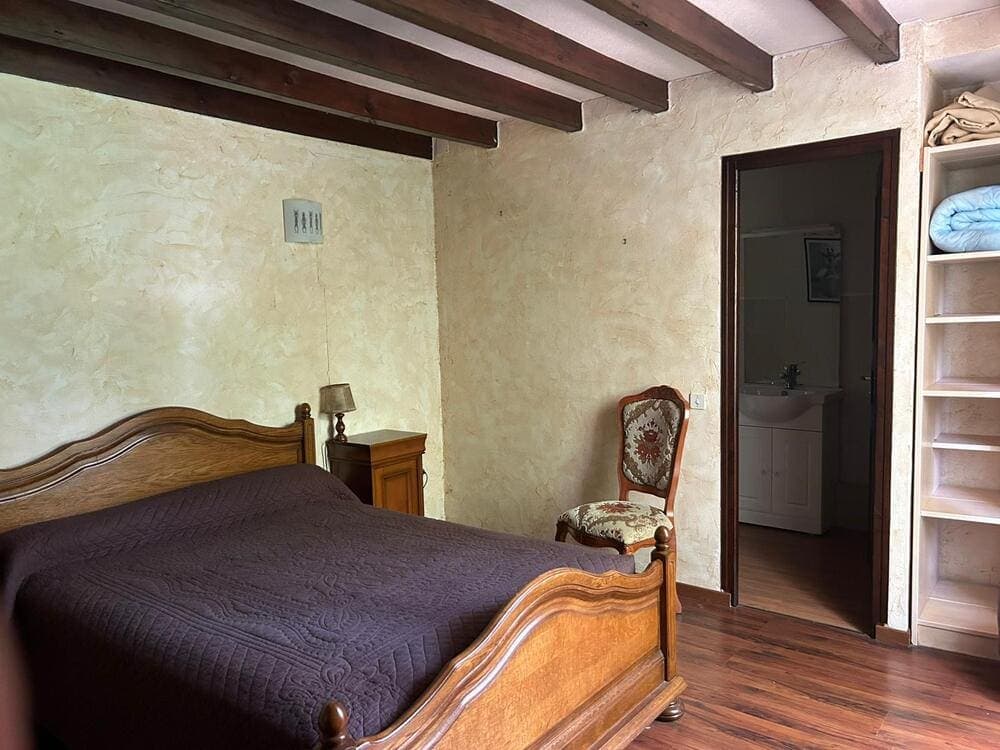 Chambre confortable du Gîte Pivoine au Domaine du Vieux Lavoir, avec sa salle de bain privative visible en arrière-plan. Cet espace douillet est un exemple de nos hébergements sur place, permettant de loger jusqu'à 55 personnes dans nos 4 gîtes. Idéal pour un repos serein après les festivités de vos mariages et grandes réceptions dans les Deux-Sèvres, offrant tout le confort nécessaire à vos invités.