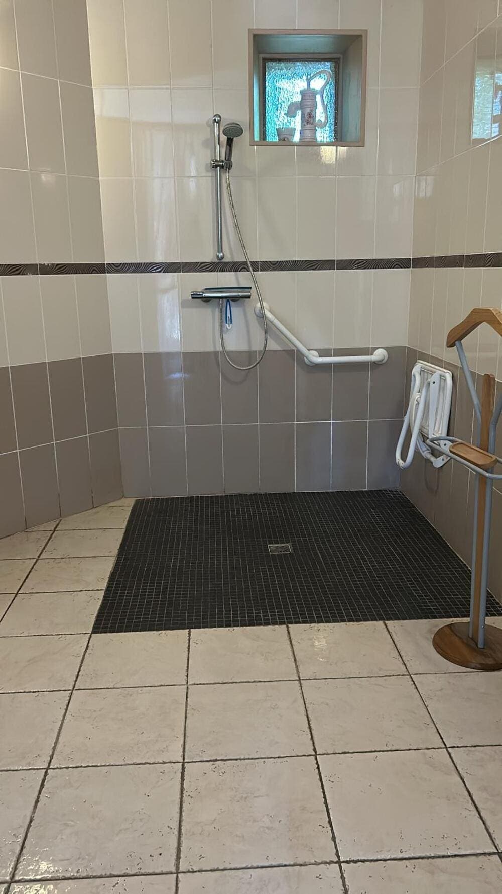 La grande salle de bain adaptée aux Personnes à Mobilité Réduite (PMR) du Gîte Rose au Domaine du Vieux Lavoir. Conçue pour offrir un maximum de confort et d'autonomie, elle dispose d'espaces généreux et d'équipements spécifiques. Cette salle de bain illustre notre engagement à proposer des hébergements entièrement accessibles pour que tous vos invités profitent pleinement de votre mariage ou grande réception dans les Deux-Sèvres en toute sérénité.