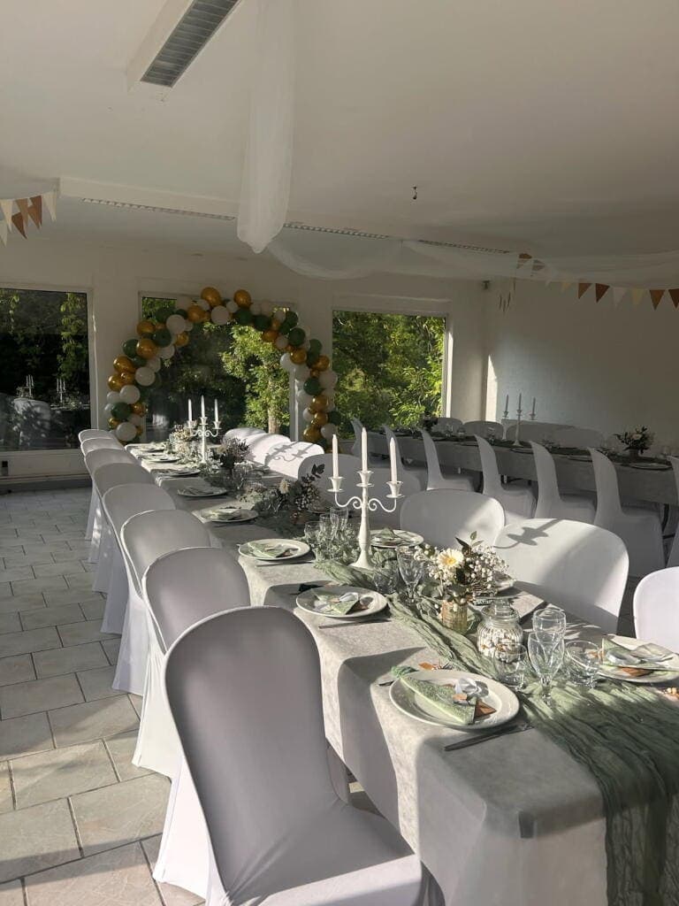 Détail des décorations d'une longue table dans la salle de réception du Domaine du Vieux Lavoir, lors d'un mariage mémorable. On y distingue les centres de table floraux, la vaisselle élégante et les éléments décoratifs qui contribuent à l' ambiance raffinée et festive . Cette vue rapprochée illustre le potentiel de personnalisation et le soin apporté à chaque détail pour créer un cadre unique pour vos réceptions et mariages dans les Deux-Sèvres.