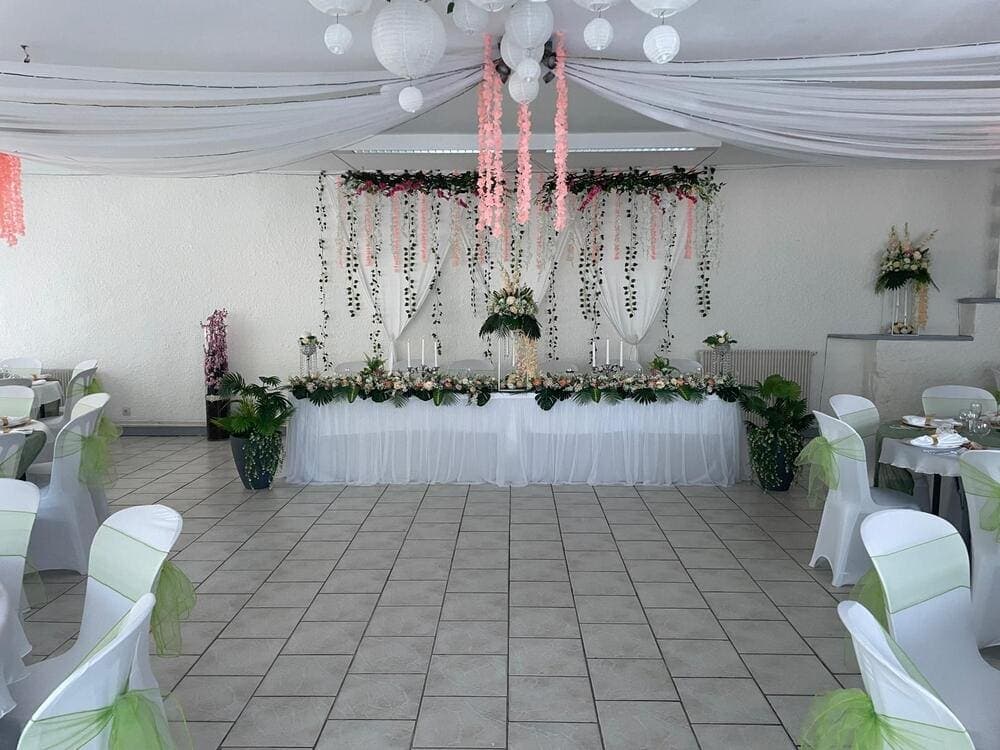 La magnifique table des mariés dans la salle de réception du Domaine du Vieux Lavoir, lors d'un mariage célébré chez nous. On y admire une décoration d'exception, avec des arrangements floraux, une vaisselle raffinée et un éclairage subtil qui met en valeur ce lieu d'honneur. Cette image délicate, capturée par nos clients, illustre l'attention personnalisée que nous apportons à chaque détail pour faire de votre union un moment inoubliable dans les Deux-Sèvres.